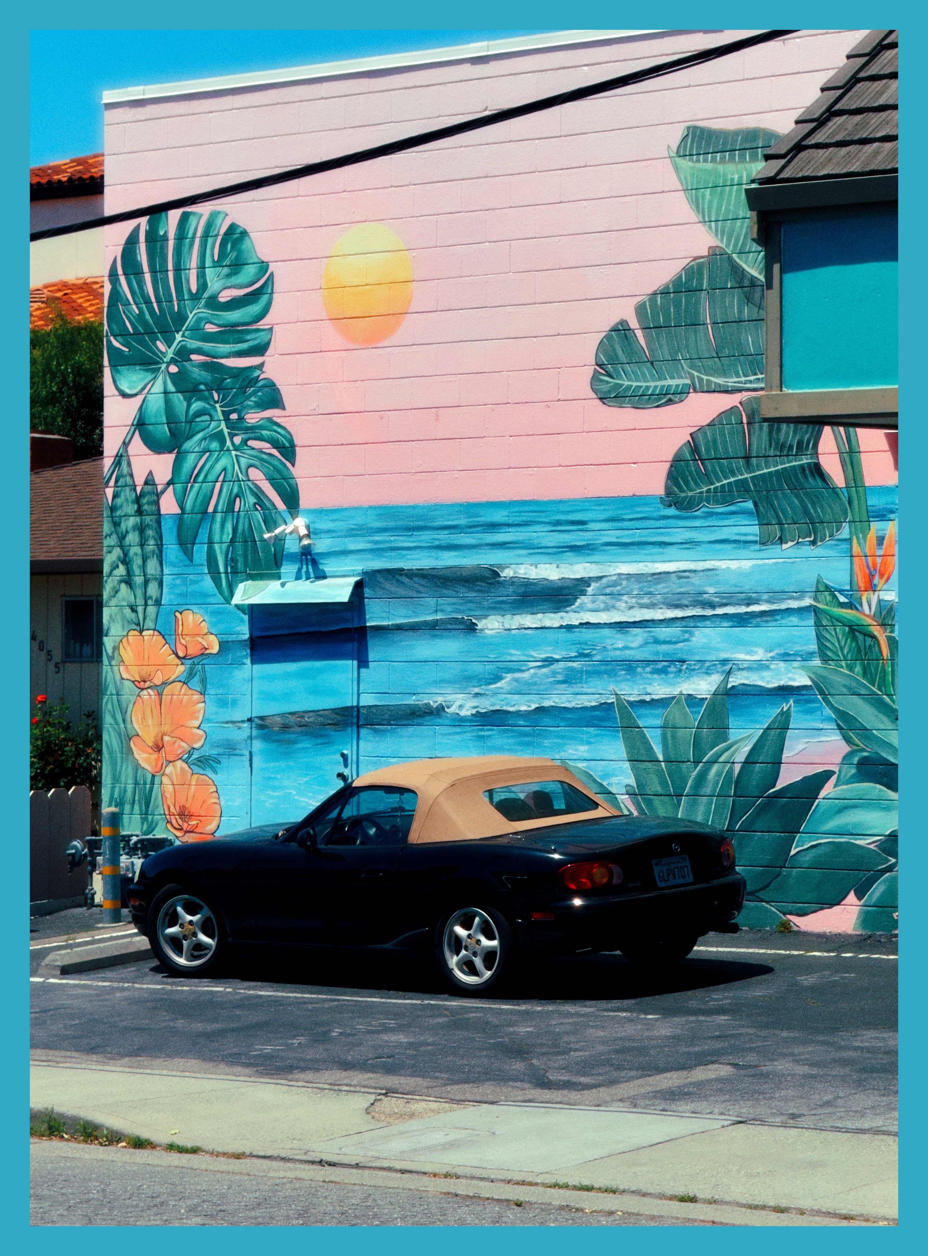 convertible parked next to a mural